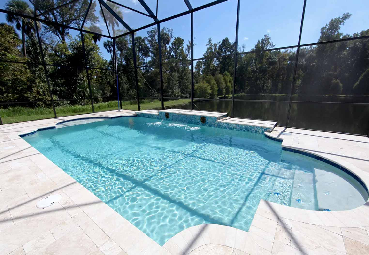 Large screene enclosed pool patio with pond in the background