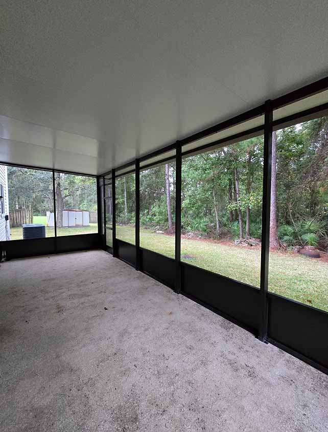 interior view of screen enclosure with tree line in the background