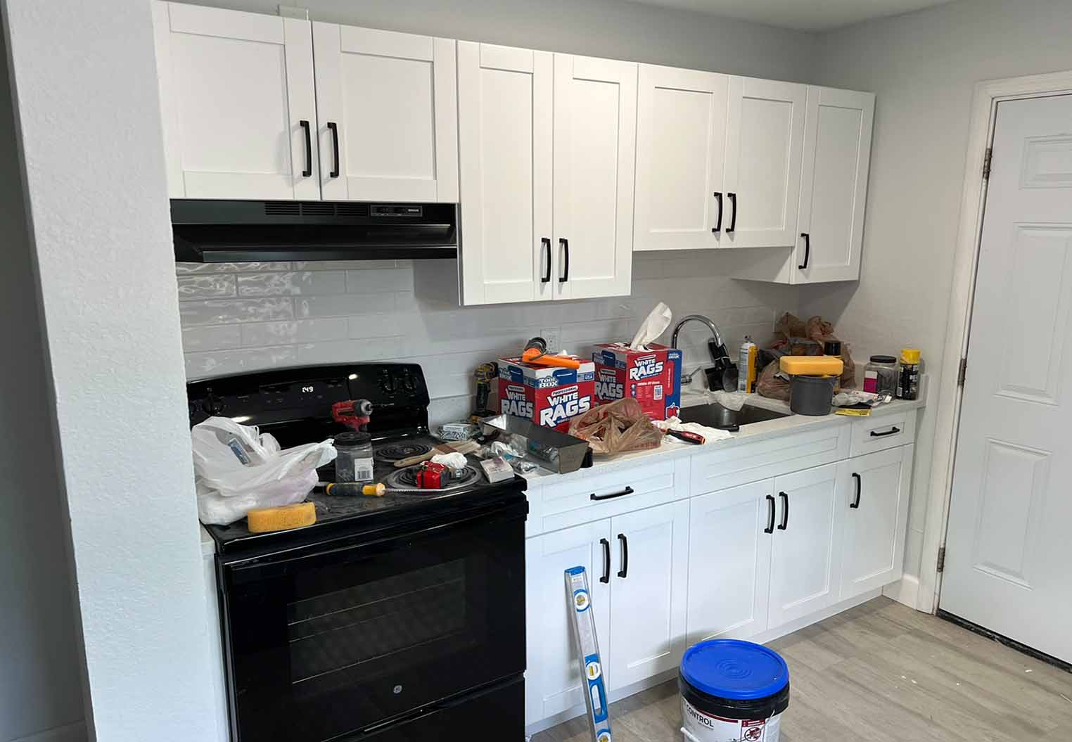 installation of new white kitchen cabinats with black pulls